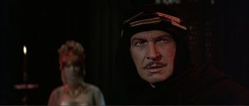 Movie still from “The Masque of the Red Death” (1964), directed by Roger Corman – A person wearing a hat; Close Up shot, Over the shoulder angle