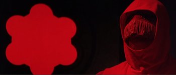 Movie still from “The Masque of the Red Death” (1964), directed by Roger Corman – A man wearing a red hat and a red jacket; Close Up shot, Low angle