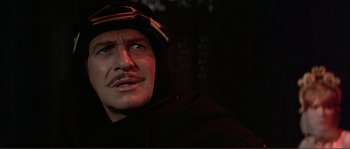 Movie still from “The Masque of the Red Death” (1964), directed by Roger Corman – A person wearing a hooded jacket; Close Up shot, Low angle