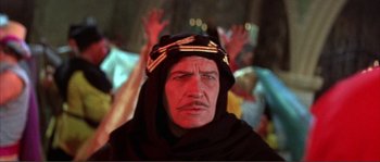 Movie still from “The Masque of the Red Death” (1964), directed by Roger Corman – An old man in a black robe and a yellow hat; Close Up shot, Low angle