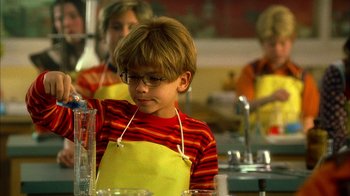 Movie still from “The Master of Disguise” (2002), directed by Perry Andelin Blake – A young boy wearing a red and yellow apron; Medium shot, High angle