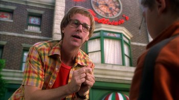 Movie still from “The Master of Disguise” (2002), directed by Perry Andelin Blake – A man in a plaid shirt is holding his hands together; Close Up shot, Over the shoulder angle