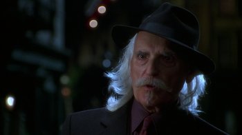 Movie still from “The Master of Disguise” (2002), directed by Perry Andelin Blake – An older man with a long white beard wearing a hat; Close Up shot, Over the shoulder angle