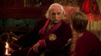 Movie still from “The Master of Disguise” (2002), directed by Perry Andelin Blake – An older man sitting in a chair next to a young woman; Medium shot, Over the shoulder angle