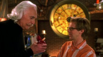 Movie still from “The Master of Disguise” (2002), directed by Perry Andelin Blake – A man holding an apple in his hand while another man looks on; Medium shot, Over the shoulder angle