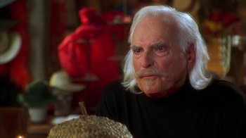 Movie still from “The Master of Disguise” (2002), directed by Perry Andelin Blake – An older man with white hair sitting in front of a basket; Close Up shot, Over the shoulder angle