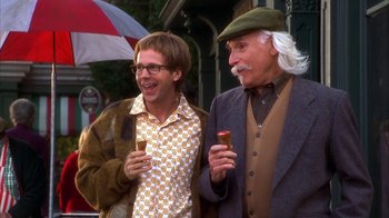 Movie still from “The Master of Disguise” (2002), directed by Perry Andelin Blake – Two men standing next to each other on the sidewalk; Medium shot, High angle