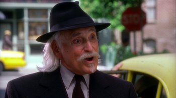 Movie still from “The Master of Disguise” (2002), directed by Perry Andelin Blake – An older man with a mustache wearing a hat; Close Up shot, Over the shoulder angle