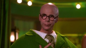 Movie still from “The Master of Disguise” (2002), directed by Perry Andelin Blake – A bald man wearing a green suit and glasses; Close Up shot, Over the shoulder angle