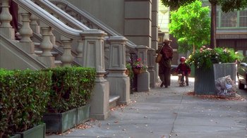 Movie still from “The Master of Disguise” (2002), directed by Perry Andelin Blake – A man walking down a sidewalk next to stairs; Extreme Wide shot, High angle