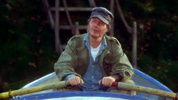 Movie still from “The Master of Disguise” (2002), directed by Perry Andelin Blake – A man sitting in a boat on the water; Medium shot, High angle