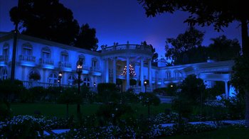 Movie still from “The Master of Disguise” (2002), directed by Perry Andelin Blake – A large white building with a large lawn in front of it at night time; Extreme Wide shot, Low angle