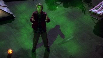 Movie still from “The Master of Disguise” (2002), directed by Perry Andelin Blake – A man standing on the ground in front of a tree; Wide shot, Overhead angle