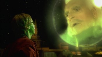 Movie still from “The Master of Disguise” (2002), directed by Perry Andelin Blake – A man with green hair and a green mask looking at a man with white hair; Close Up shot, Over the shoulder angle