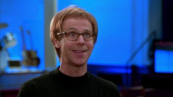 Movie still from “The Master of Disguise” (2002), directed by Perry Andelin Blake – A person wearing glasses and smiling; Close Up shot, Over the shoulder angle