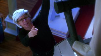 Movie still from “The Master of Disguise” (2002), directed by Perry Andelin Blake – A man wearing a white hard hat standing in front of a mirror; Medium shot, Low angle