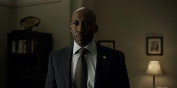 Movie still from “House of Cards” (2013), created by Beau Willimon – A man in a suit and tie standing in a room; Close Up shot, Low angle