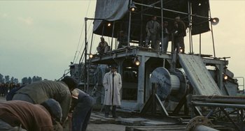 Movie still from “The Mattei Affair” (1972), directed by Francesco Rosi – A group of men standing on top of a boat; Wide shot, Low angle
