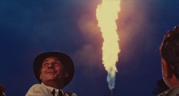 Movie still from “The Mattei Affair” (1972), directed by Francesco Rosi – A man in a hat looking up at a rocket launch; Medium shot, Low angle