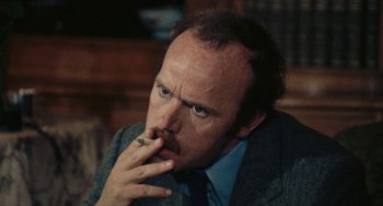 Movie still from “The Mattei Affair” (1972), directed by Francesco Rosi – A person wearing a suit and tie; Close Up shot, High angle