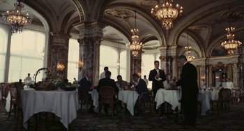 Movie still from “The Mattei Affair” (1972), directed by Francesco Rosi – A group of people sitting at tables in a restaurant; Wide shot, High angle