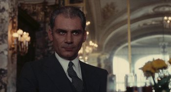 Movie still from “The Mattei Affair” (1972), directed by Francesco Rosi – A person wearing a suit and tie; Close Up shot, Over the shoulder angle