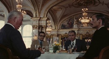 Movie still from “The Mattei Affair” (1972), directed by Francesco Rosi – Two men sitting at a dinner table with wine glasses; Wide shot, Over the shoulder angle
