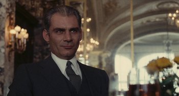 Movie still from “The Mattei Affair” (1972), directed by Francesco Rosi – A person wearing a suit and tie; Close Up shot, Low angle