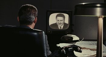 Movie still from “The Mattei Affair” (1972), directed by Francesco Rosi – An older man sitting in front of a television; Medium shot, Over the shoulder angle
