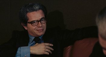 Movie still from “The Mattei Affair” (1972), directed by Francesco Rosi – A person wearing a suit and tie; Close Up shot, Over the shoulder angle