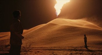 Movie still from “The Mattei Affair” (1972), directed by Francesco Rosi – A desert scene with a person walking in the background; Extreme Wide shot, High angle