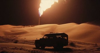 Movie still from “The Mattei Affair” (1972), directed by Francesco Rosi – A truck is parked in the desert near a gas flare; Extreme Wide shot, Low angle