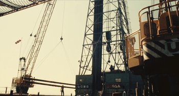 Movie still from “The Mattei Affair” (1972), directed by Francesco Rosi – A large crane that is next to a building; Extreme Wide shot, Low angle