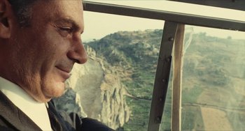 Movie still from “The Mattei Affair” (1972), directed by Francesco Rosi – A person looking out a helicopter window; Close Up shot, Low angle