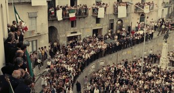 Movie still from “The Mattei Affair” (1972), directed by Francesco Rosi – A crowd of people standing on the side of a building; Extreme Wide shot, High angle