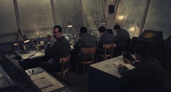 Movie still from “The Mattei Affair” (1972), directed by Francesco Rosi – A group of men sitting at a table in a room; Medium shot, High angle
