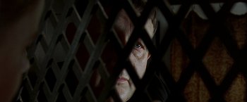 Movie still from “The Messenger: The Story of Joan of Arc” (1999), directed by Luc Besson – An older woman looking through a fence; Extreme Close Up shot, High angle