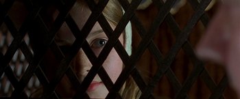 Movie still from “The Messenger: The Story of Joan of Arc” (1999), directed by Luc Besson – A little girl is looking through a wooden fence; Close Up shot, Overhead angle
