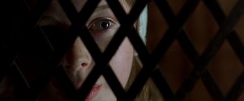 Movie still from “The Messenger: The Story of Joan of Arc” (1999), directed by Luc Besson – A person's face behind a fence; Extreme Close Up shot, Overhead angle