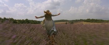 Movie still from “The Messenger: The Story of Joan of Arc” (1999), directed by Luc Besson – A woman is running through a field with her arms outstretched; Wide shot, High angle