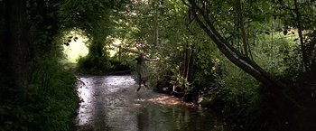 Movie still from “The Messenger: The Story of Joan of Arc” (1999), directed by Luc Besson – A woman is jumping in the air over a river; Wide shot, Low angle