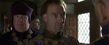 Movie still from “The Messenger: The Story of Joan of Arc” (1999), directed by Luc Besson – A person wearing a necklace; Close Up shot, Over the shoulder angle