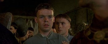 Movie still from “The Messenger: The Story of Joan of Arc” (1999), directed by Luc Besson – Two men standing next to each other in front of a wall; Close Up shot, Low angle