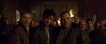 Movie still from “The Messenger: The Story of Joan of Arc” (1999), directed by Luc Besson – Two men standing next to each other in front of a fireplace; Close Up shot, Low angle