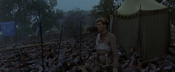Movie still from “The Messenger: The Story of Joan of Arc” (1999), directed by Luc Besson – A man standing in front of a bunch of corpses; Wide shot, High angle