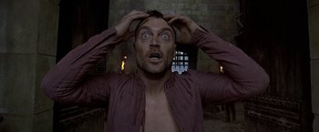 Movie still from “The Messenger: The Story of Joan of Arc” (1999), directed by Luc Besson – A man with his mouth wide open holding his head; Close Up shot, Low angle