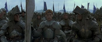 Movie still from “The Messenger: The Story of Joan of Arc” (1999), directed by Luc Besson – A group of men in armor standing next to each other in a field; Medium shot, Low angle