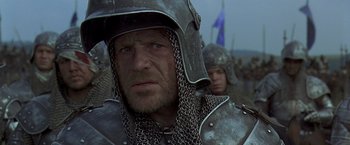 Movie still from “The Messenger: The Story of Joan of Arc” (1999), directed by Luc Besson – A person wearing a chain mail helmet; Close Up shot, Over the shoulder angle