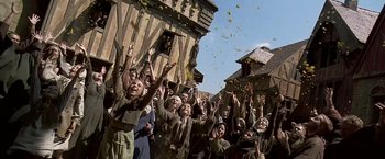 Movie still from “The Messenger: The Story of Joan of Arc” (1999), directed by Luc Besson – A group of people standing next to each other on a street; Wide shot, Low angle