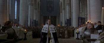 Movie still from “The Messenger: The Story of Joan of Arc” (1999), directed by Luc Besson – A crowd of people standing in front of a cathedral; Wide shot, High angle